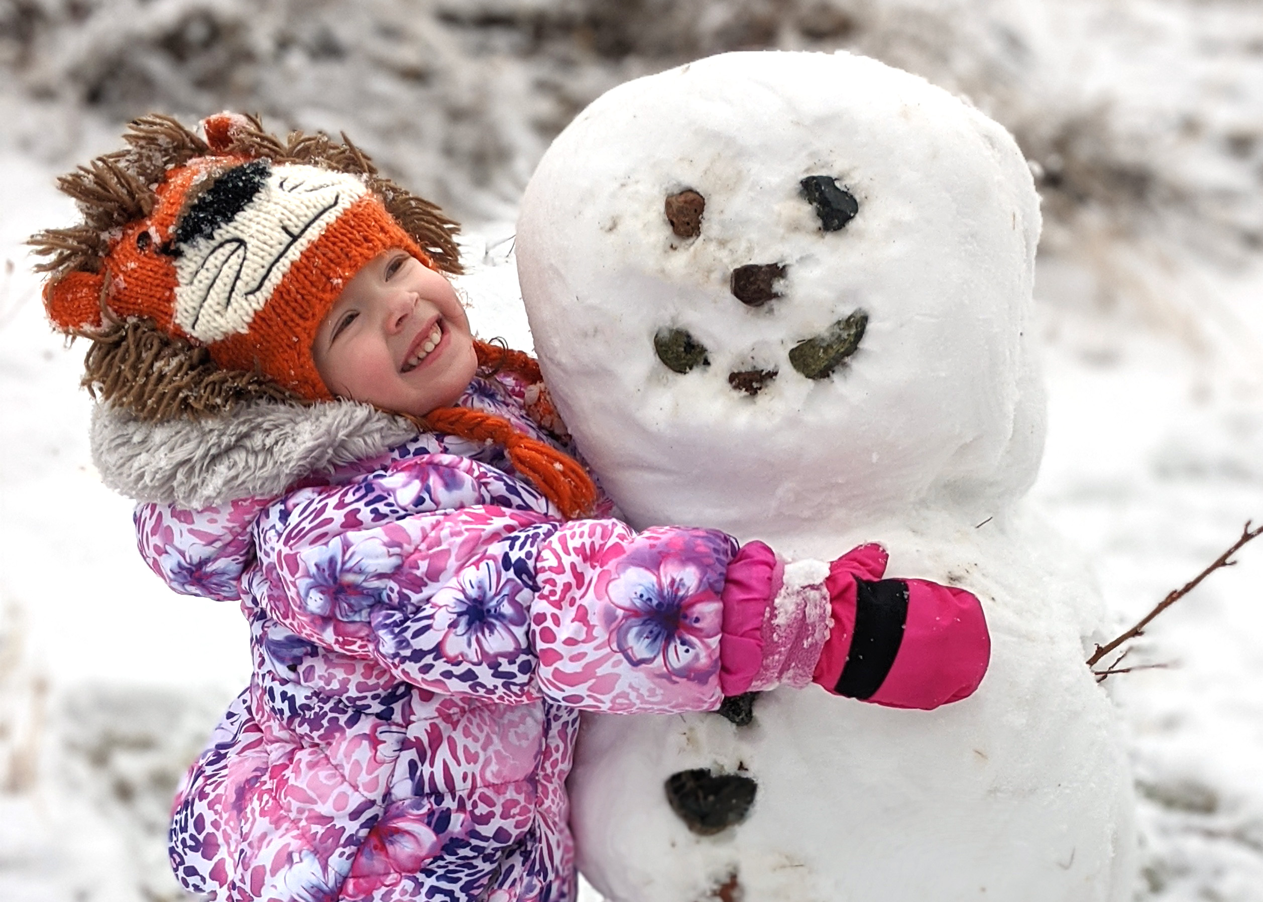Little girl hugging a snow person