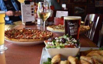 A pizza, a salad and a glass of beer being enjoyed at Freeman's Little New York.