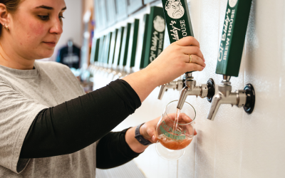 A bartender pours beer from a tap at Ol' Biddy's Brew House.