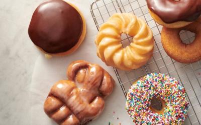 A flatlay of a variety of doughnuts on a counter.